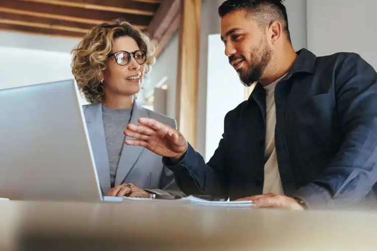 een-klantbeeld-voor-uw hele-organisatie Twee collega's bekijken samen het klantoverzicht in Appraesto relatiebeheer op een laptop